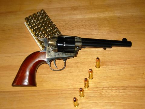 1996 Ford Bronco - A revolver and ammunition are displayed on a wooden surface, with a website logo in the corner.