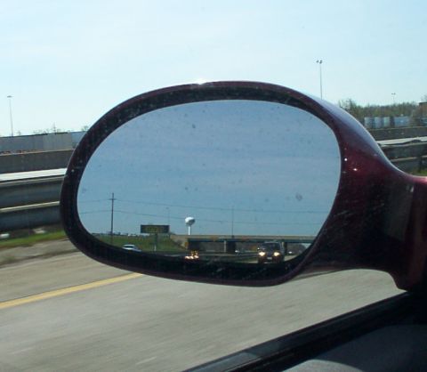 1998 Ford Taurus - Reflection in a side mirror shows a highway with a water tower and another vehicle.