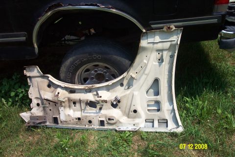 1992 Ford Bronco - A detached vehicle door is shown in the foreground, with the wheel well of another vehicle visible behind it.