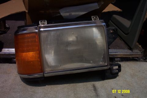 1992 Ford Bronco - Headlight assembly with amber turn signal and chrome trim, likely for an older vehicle.