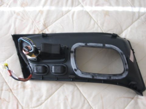 1995 Ford Thunderbird - A detached car door panel with electrical connectors and a large opening is shown against a quilted background.