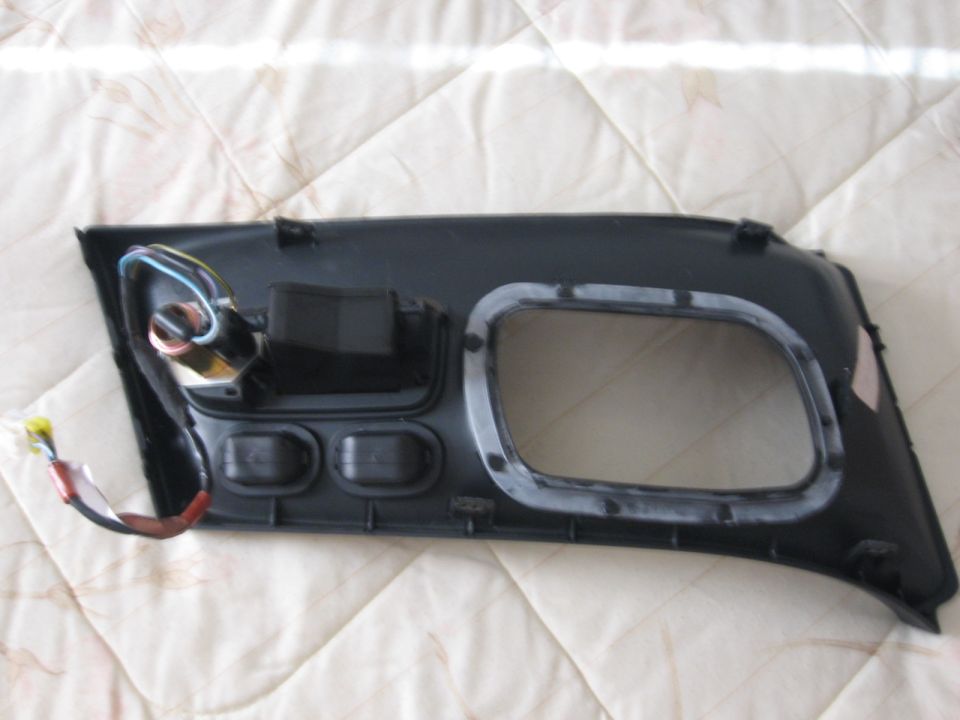 Car door panel with wiring and mounting points. Has a large cutout for a speaker or window mechanism