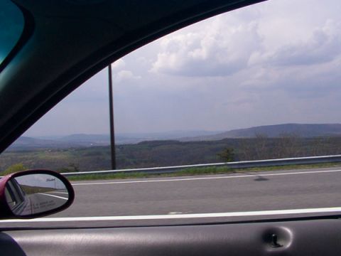 1998 Ford Taurus - Driving through scenic countryside, with a view from the passenger window and a reflection in the side mirror.