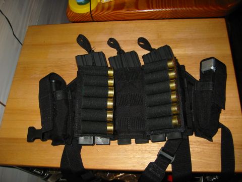1996 Ford Bronco - A black tactical vest is laid out on a wooden surface, loaded with various ammunition types.