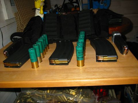 1996 Ford Bronco - A collection of ammunition magazines and green shotgun shells are laid out on a table.