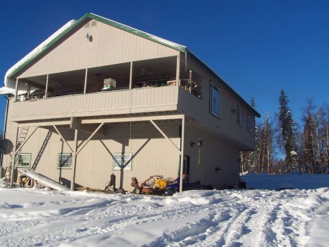 1989 Ford Bronco II - Winter scene of a house with snow covering the landscape and some equipment stored outside.