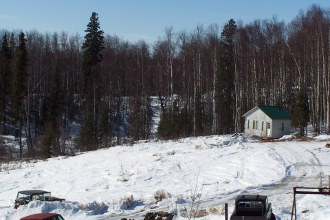 1989 Ford Bronco II - A black SUV is visible in a snowy landscape next to a small white building.