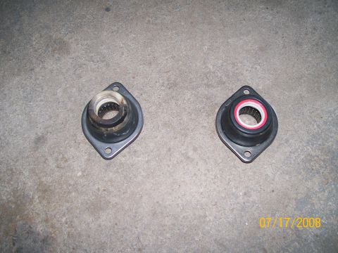 1995 Mercury Grand Marquis - A comparison of a used and a new suspension strut mount is shown on a concrete floor.