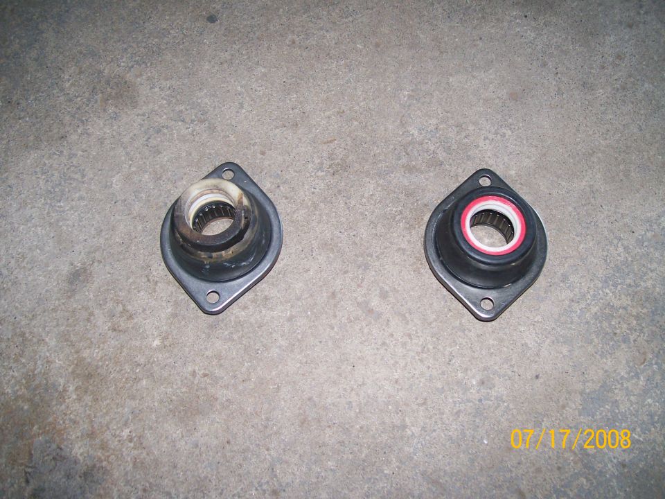 Two suspension strut mounts, one used and one new, on a concrete surface