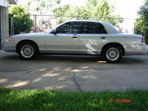 1998 Ford Crown Victoria - Side profile of a silver 1998 Ford Crown Victoria parked outdoors.