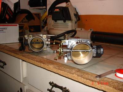 1998 Ford Crown Victoria - Two throttle bodies are shown on a workbench, with a leaf blower in the background.