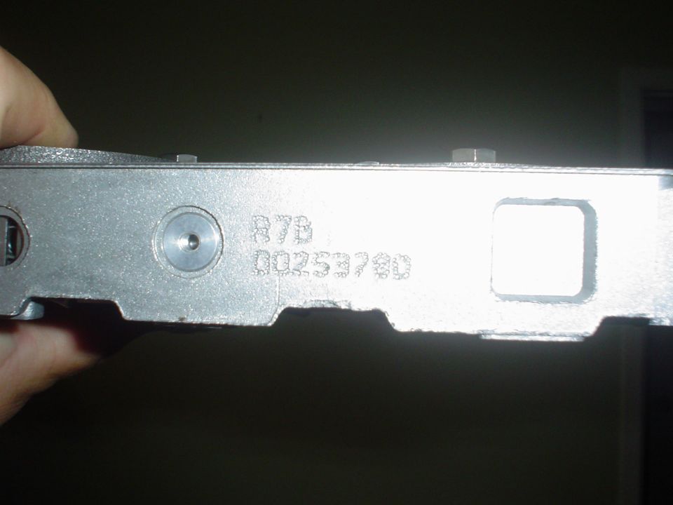 Close-up of a metal part with stamped numbers R7B 00253780