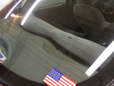 1998 Ford Taurus - Interior view of a 1998 Ford Taurus, showing the rear seats and window with an American flag sticker.