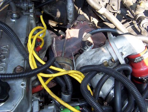 1986 Toyota Hilux - Close-up view of an engine bay, a turbocharger and various hoses and wires.