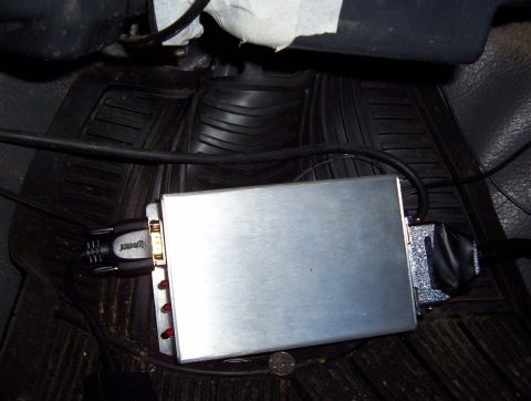 1986 Toyota Hilux - A silver engine control unit is connected to wiring harnesses on the floor of a vehicle.