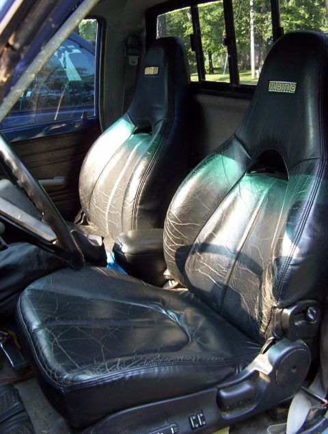 1986 Toyota Hilux - Black leather bucket seats with Momo branding are visible inside the vehicle's cabin.