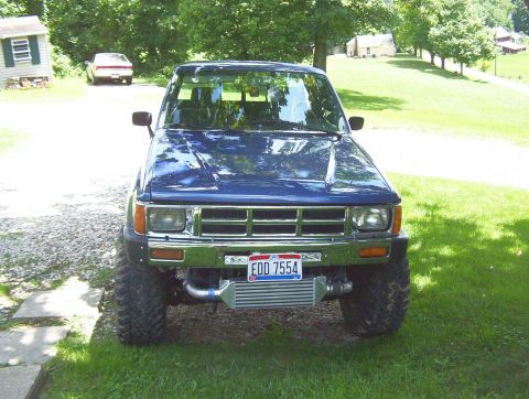 1986 Toyota Hilux - Front view of a blue 1986 Toyota Hilux pickup truck, modified with an aftermarket intercooler.