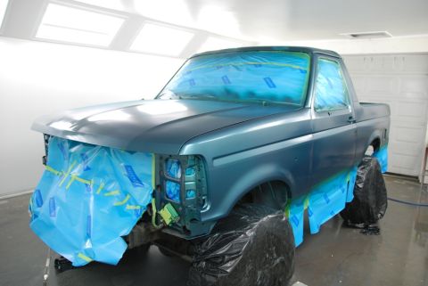 1996 Ford Bronco - A blue Ford Bronco is being prepped for painting inside a spray booth.