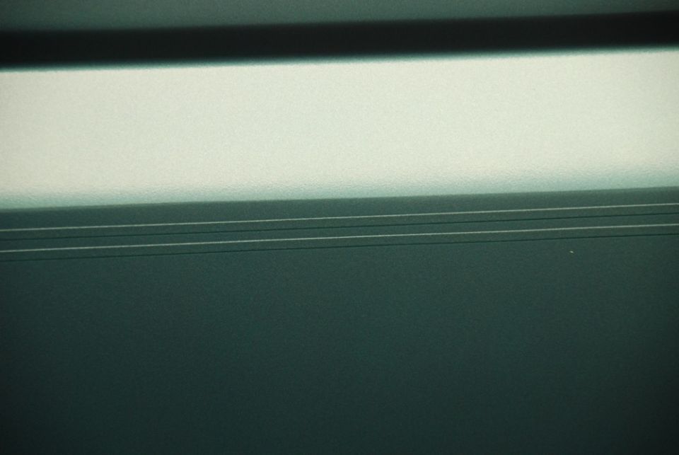 Dark green textured surface with horizontal lines and bright upper section
