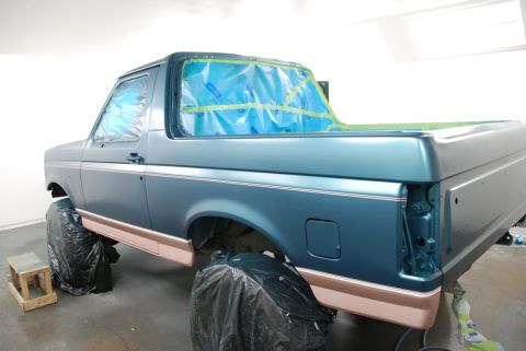 1996 Ford Bronco - Ford Bronco in paint booth, windows covered for protection during spray application.