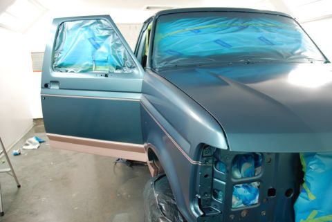 1996 Ford Bronco - A truck is being prepped for painting, with its door open and covered in protective plastic.