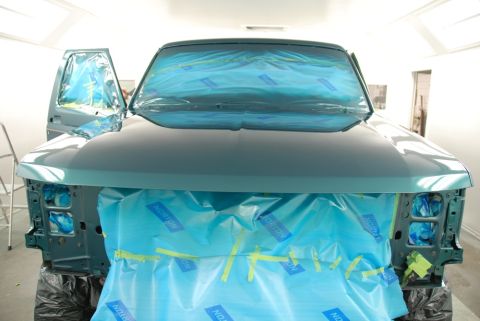 1996 Ford Bronco - SUV front end is masked with blue sheeting and tape, ready for a new coat of paint in a spray booth.
