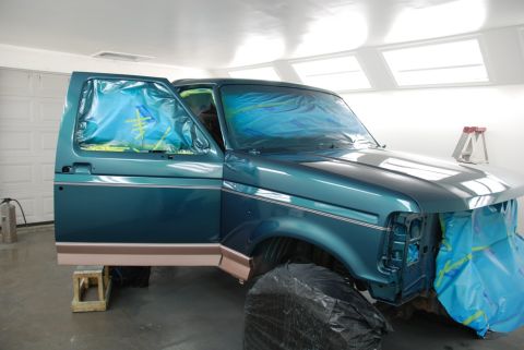 1996 Ford Bronco - Ford Bronco in paint booth, doors open, front end covered for painting.
