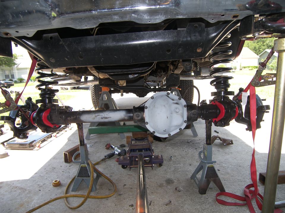 Undercarriage view of a vehicle's suspension and differential on jack stands