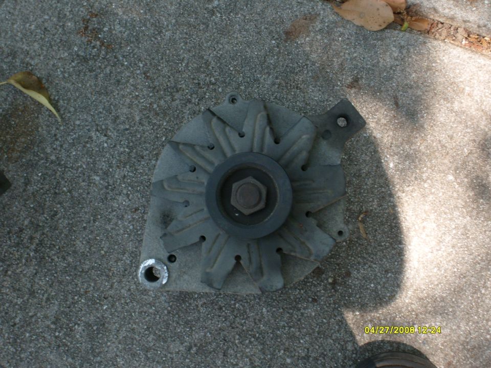 Automotive alternator lying on concrete, dated April 27 2006