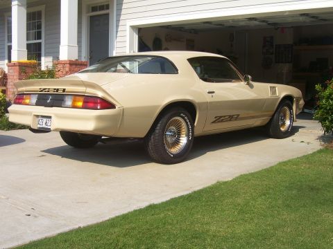 1979 Chevrolet Camaro - Tan 1979 Chevrolet Camaro Z28 with gold wheels parked in front of a garage.