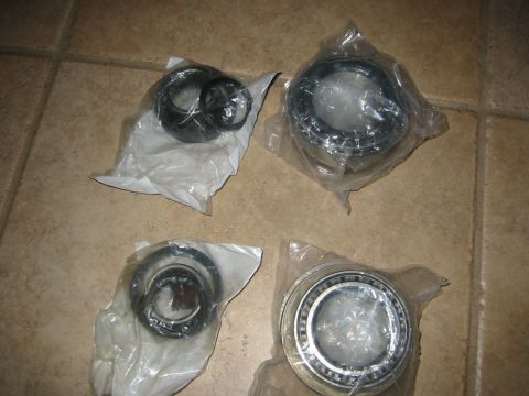 1995 Ford Bronco - Four new wheel bearings are packaged and laid out on a tiled surface.