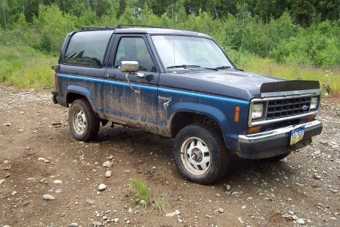 1989 Ford Bronco II - This blue 1989 Ford Bronco II is shown from a 3/4 front angle on a muddy, gravelly surface.