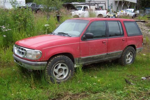1989 Ford Bronco II - This red SUV appears to be a 1995 Ford Explorer, not a 1989 Bronco II, based on its body style and grille.
