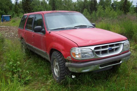 1989 Ford Bronco II - This red 1995 Ford Explorer is seen parked in a grassy, wooded area.