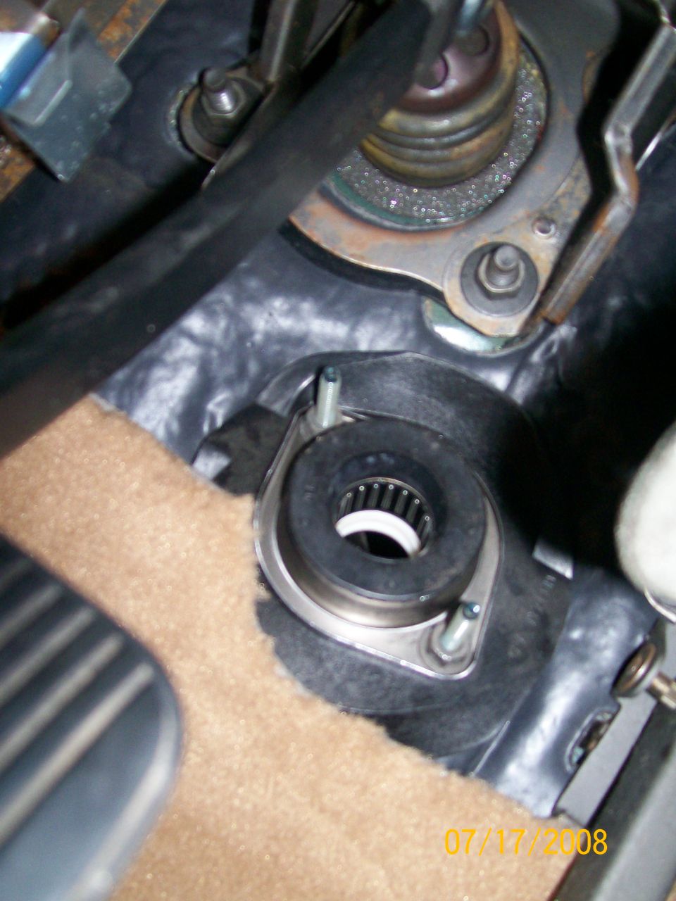Close-up of a steering column bearing assembly with a rubber seal and metal housing