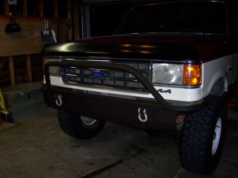 1991 Ford Bronco - The front grille and headlights of a Ford truck are visible, along with a custom bumper and 4x4 badging.