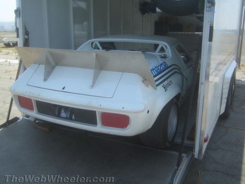 1985 Ford Mustang - A white Mazda race car with a large rear spoiler and Hoosier branding is being loaded into a trailer.