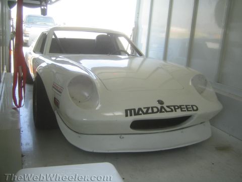1985 Ford Mustang - A white MazdaSpeed race car is seen from the front, likely being transported or stored.