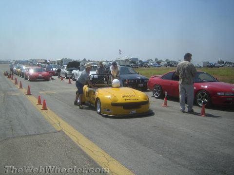 1985 Ford Mustang - Autocross event with multiple cars lined up, a yellow convertible sports car in the foreground.