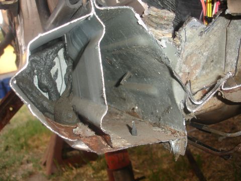 1991 Ford Taurus - The structural integrity of this vehicle's frame appears compromised, showing significant rust and damage.