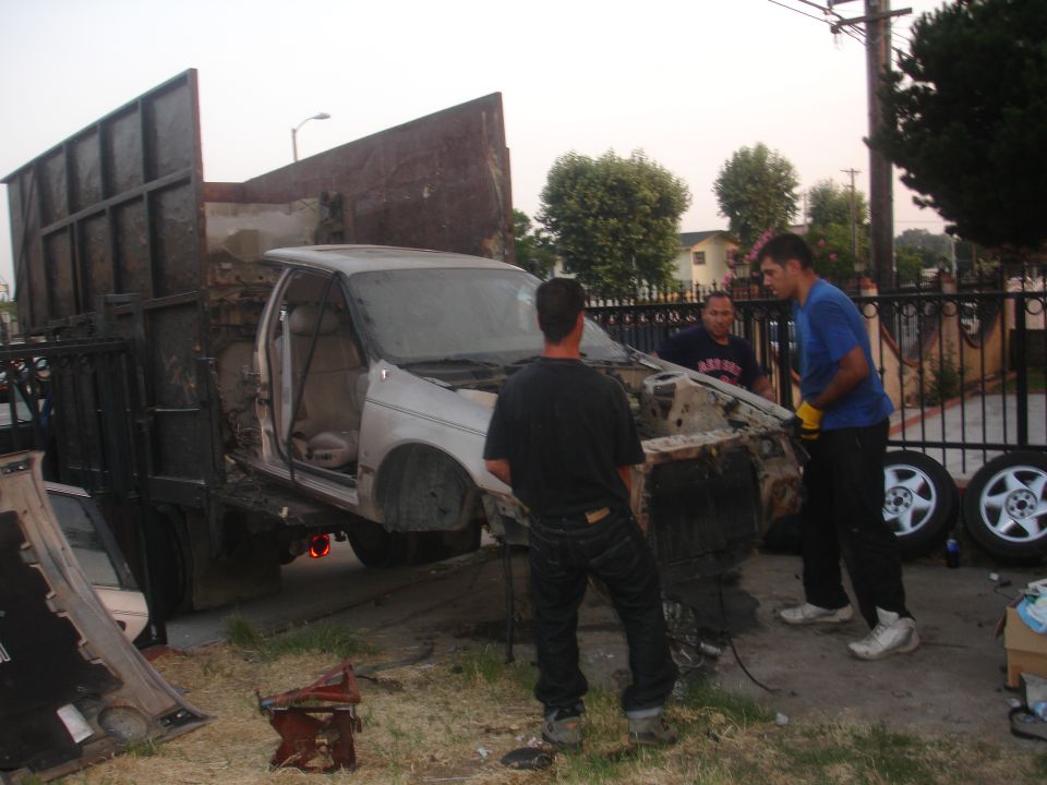 1991 Ford Taurus being loaded onto a flatbed truck, front view