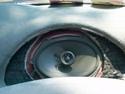 1998 Ford Taurus - Close-up of a car's interior showing an exposed speaker and surrounding dashboard trim.