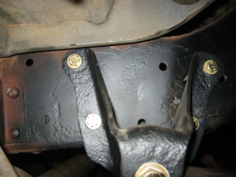 1995 Ford Bronco - A close-up view of a vehicle's frame with a bolted bracket, likely part of the suspension or chassis.
