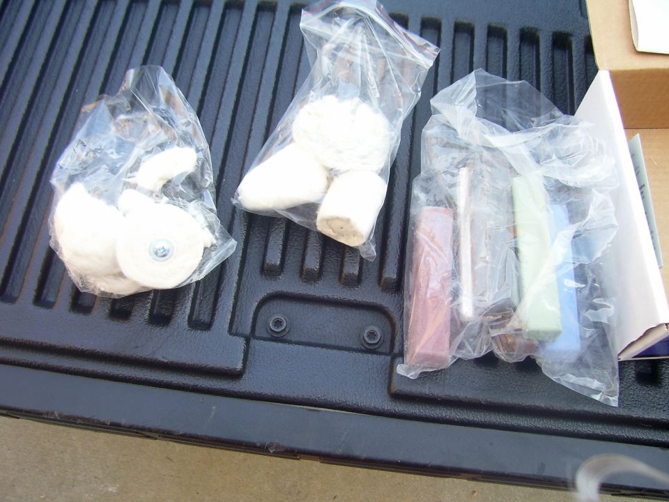 Three plastic bags containing polishing wheels and compound bars on a truck bed