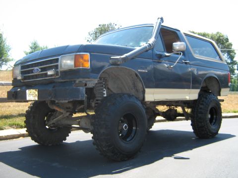 1990 Ford Bronco - This modified Ford Bronco features a snorkel and lifted suspension, indicating off-road capabilities.