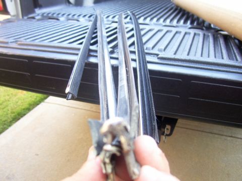 1979 Chevrolet Camaro - Close-up of trim pieces being held over the ribbed surface of a truck bed.