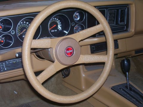 1979 Chevrolet Camaro - The interior of a 1979 Chevrolet Camaro features a tan dashboard, steering wheel, and center console.