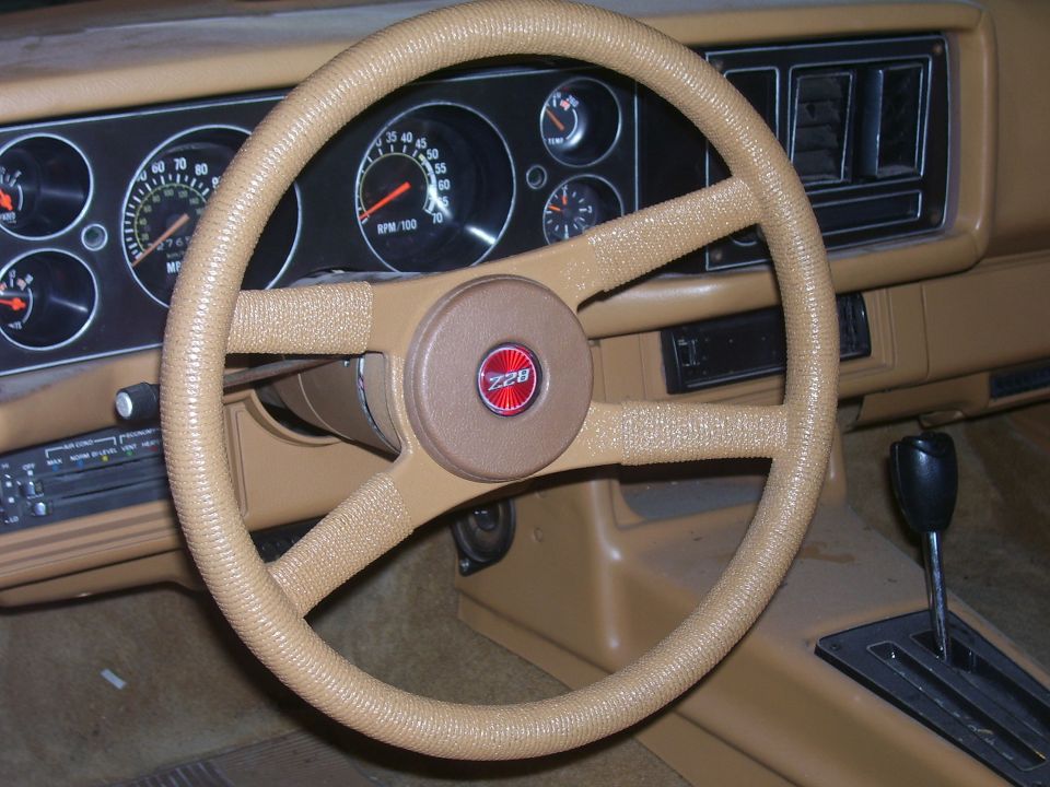 tan interior of a 1979 Chevrolet Camaro with Z28 badge on steering wheel and gauges