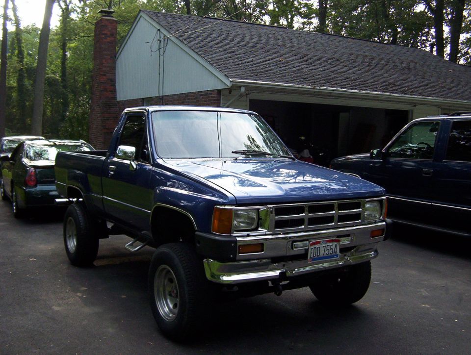 blue pickup truck parked in driveway, another car and SUV behind it