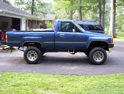 1986 Toyota Hilux - A blue 1986 Toyota Hilux pickup truck is parked in a driveway next to an SUV.